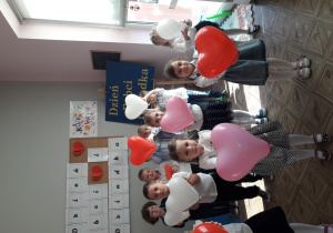 Dzieci z balonikami w kształcie serduszek recytują wiersze
